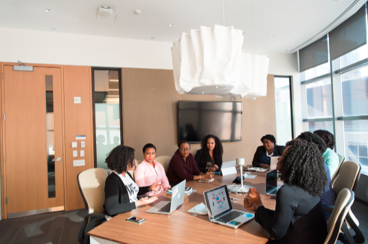 A team sitting at a conference table discussing revenue leakage examples.