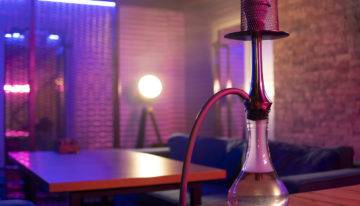 Hookah stands on the table in pink blue neon light