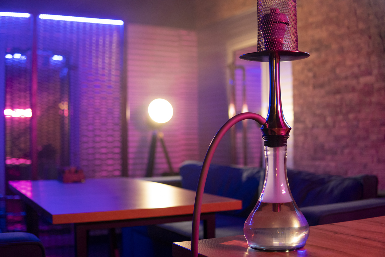 Hookah stands on the table in pink blue neon light